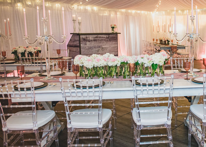 a bride and groom dancing under a wedding tent